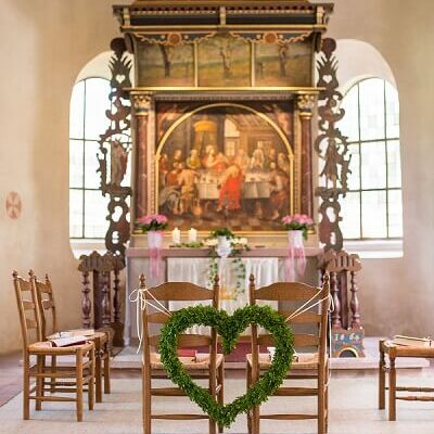 Herzgesteck zur Hochzeit vor einem Altar